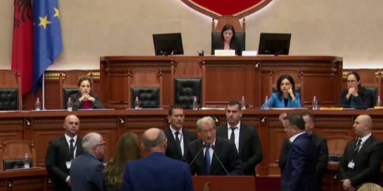 E FUNDIT/ “Plas” në Kuvend, Berisha-Flamur Noka dhe të tijtë pushtojnë foltoren, ndërpritet…